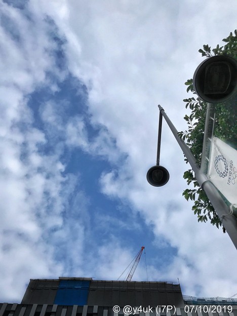 1Year to Go“TOKYO2020”五輪まで#あと1年、ちょうど2019.7.24～梅雨の晴れ間・雲の隙き間・五輪フラッグ・街灯・新緑・開発ビル建設中クレーン・街角～7.10旅の途中3蒸し暑い