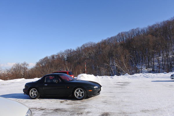 青い空、白い地面、緑のロードスター 青い空、白い地面、緑のロードスター