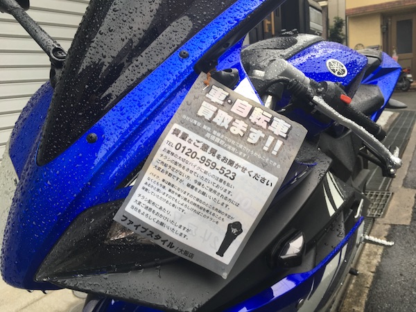 雨に打たれる長男のバイクに付いている紙